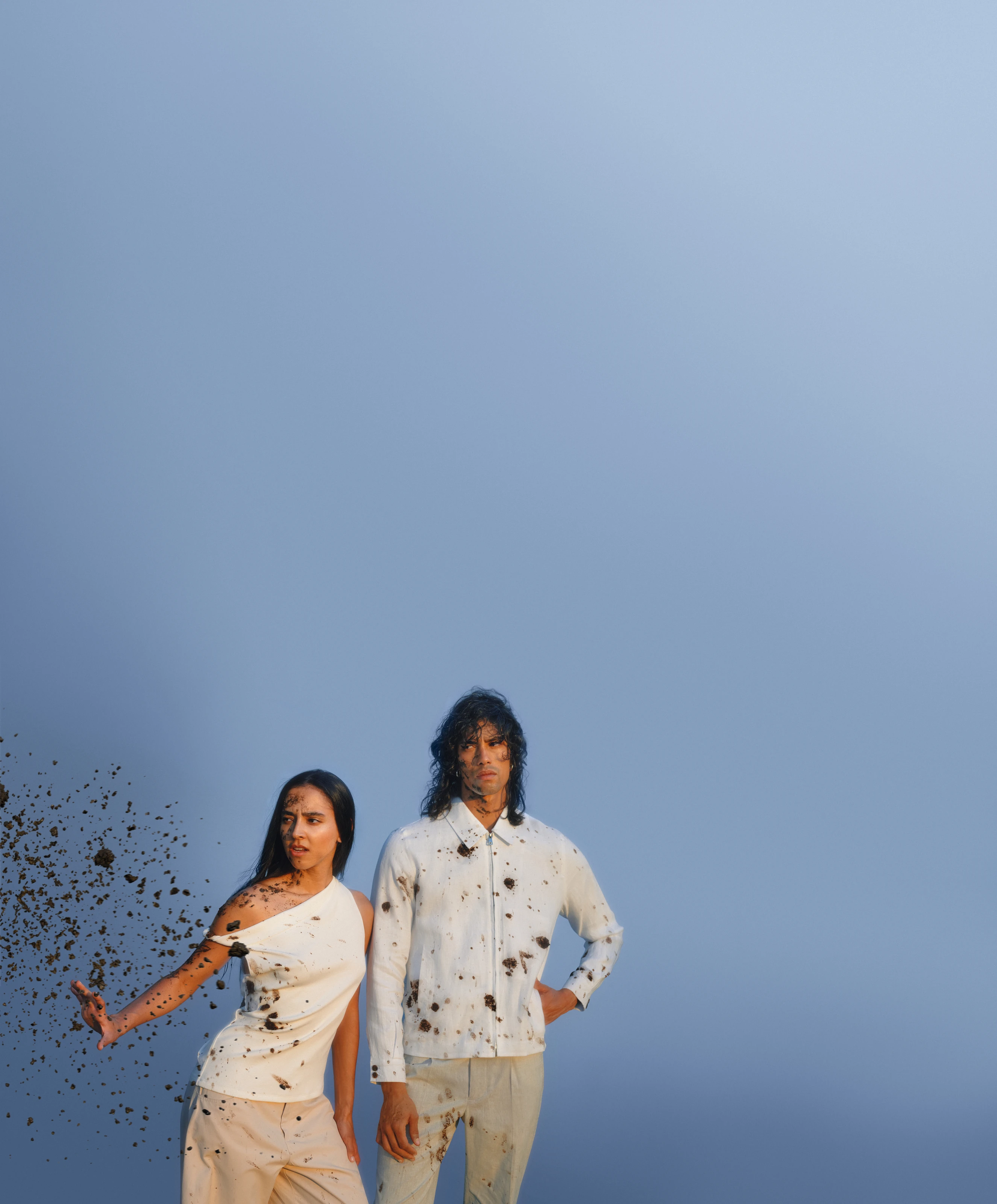 A couple in white clothes splashed with mud